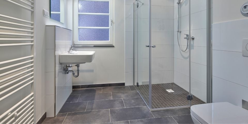 A Modern Bathroom That Is Primarily White and Grey