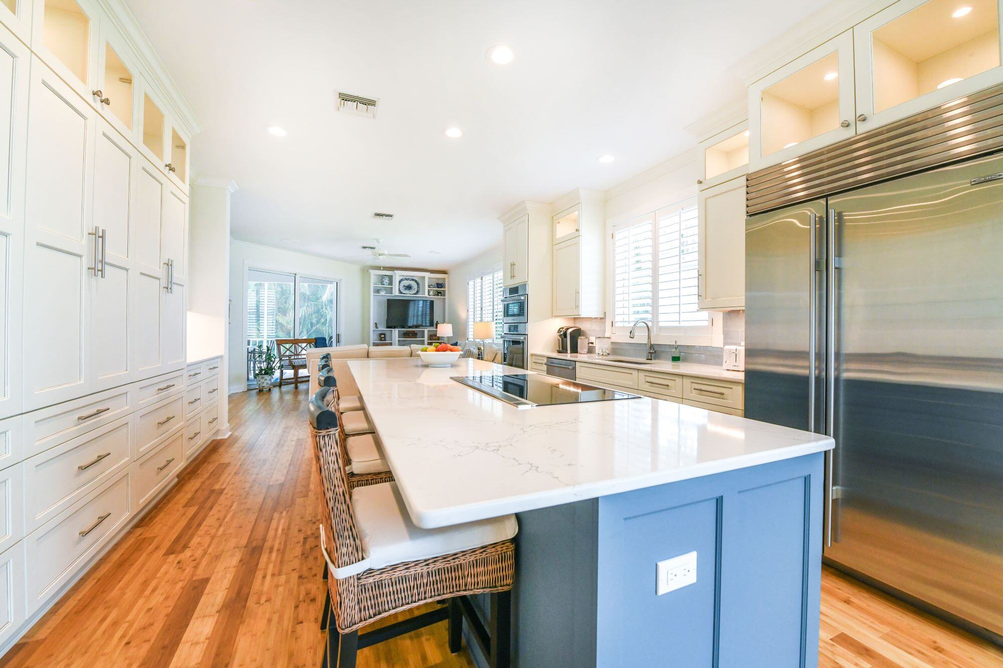 Seating at Large Island in New Kitchen with Storage and Wood Floors