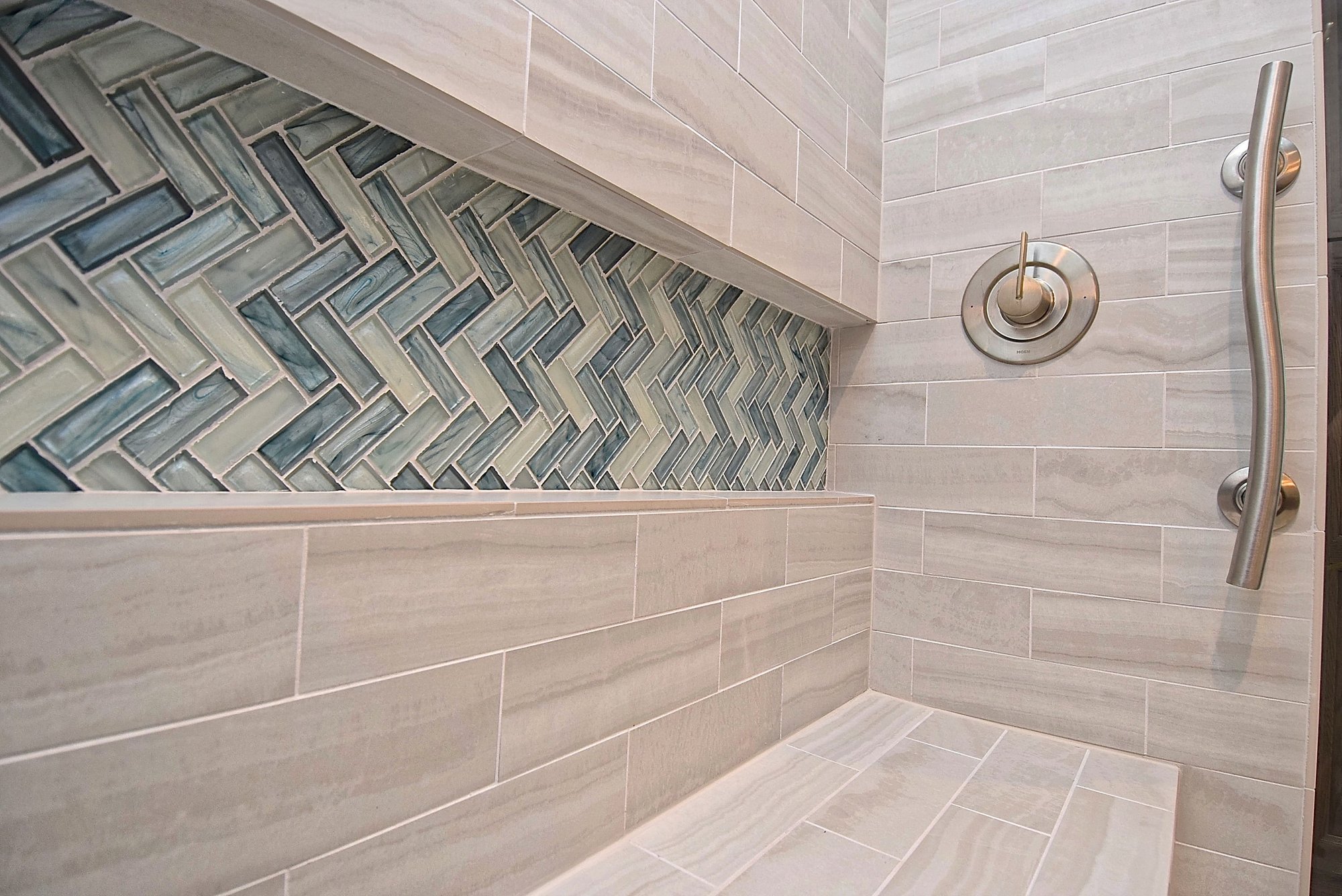 Shower Bench and Grab Bar in ADA Bathroom Renovation with Blue Herringbone Accent Tile in Niche