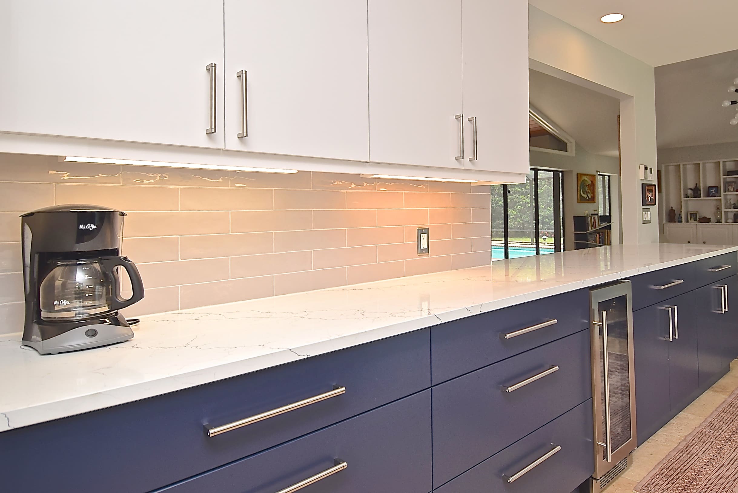 Flat Front Cabinets with Elongated Subway Tile Backsplash and White Counters in Sarasota Kitchen Remodel