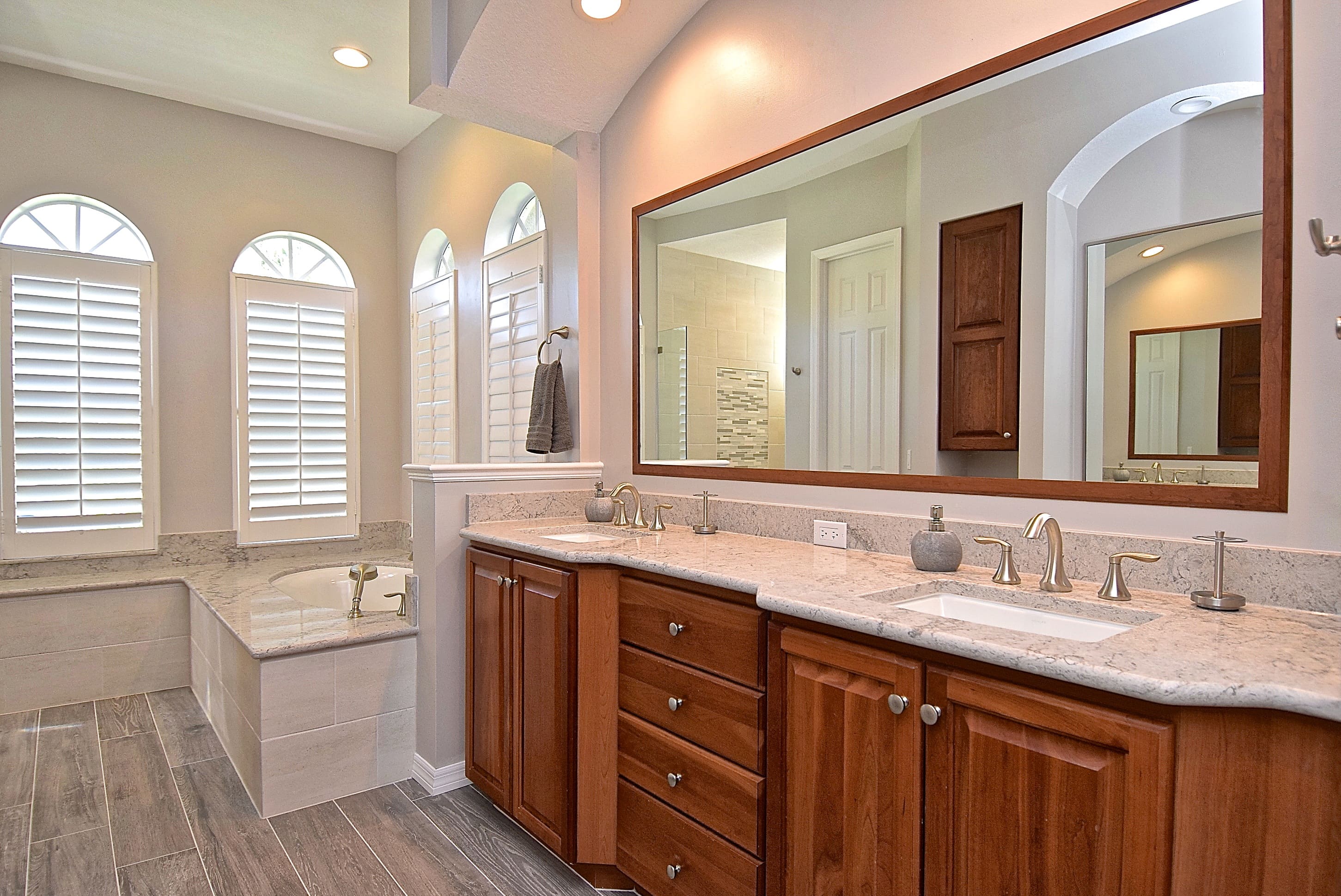 Double Wood Vanity with Large Mirror and Built In Soaking Tub in Remodeled Sarasota Bathroom