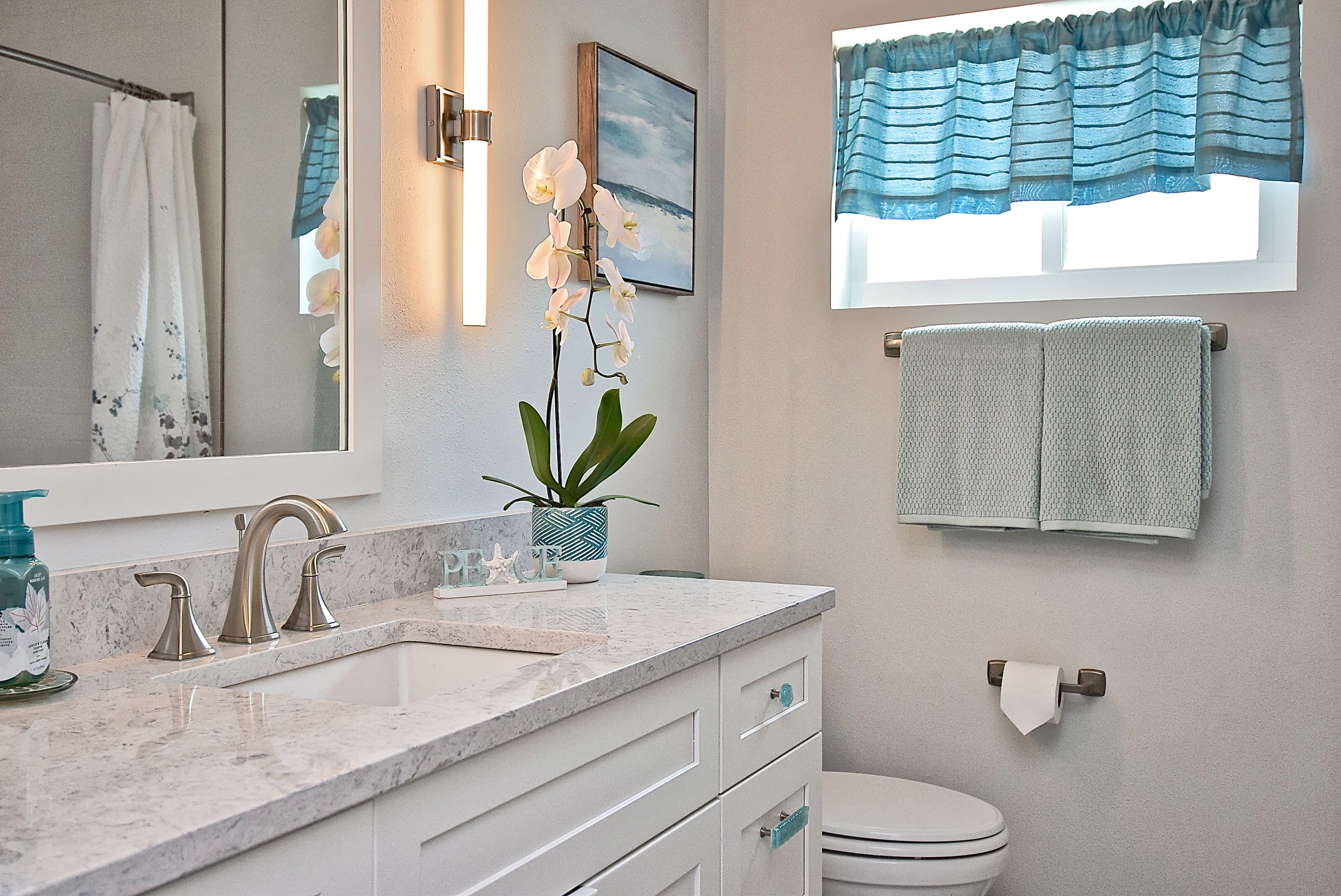 Marble Look Countertop Vanity with White Cabinets in Remodeled Sarasota Bathroom