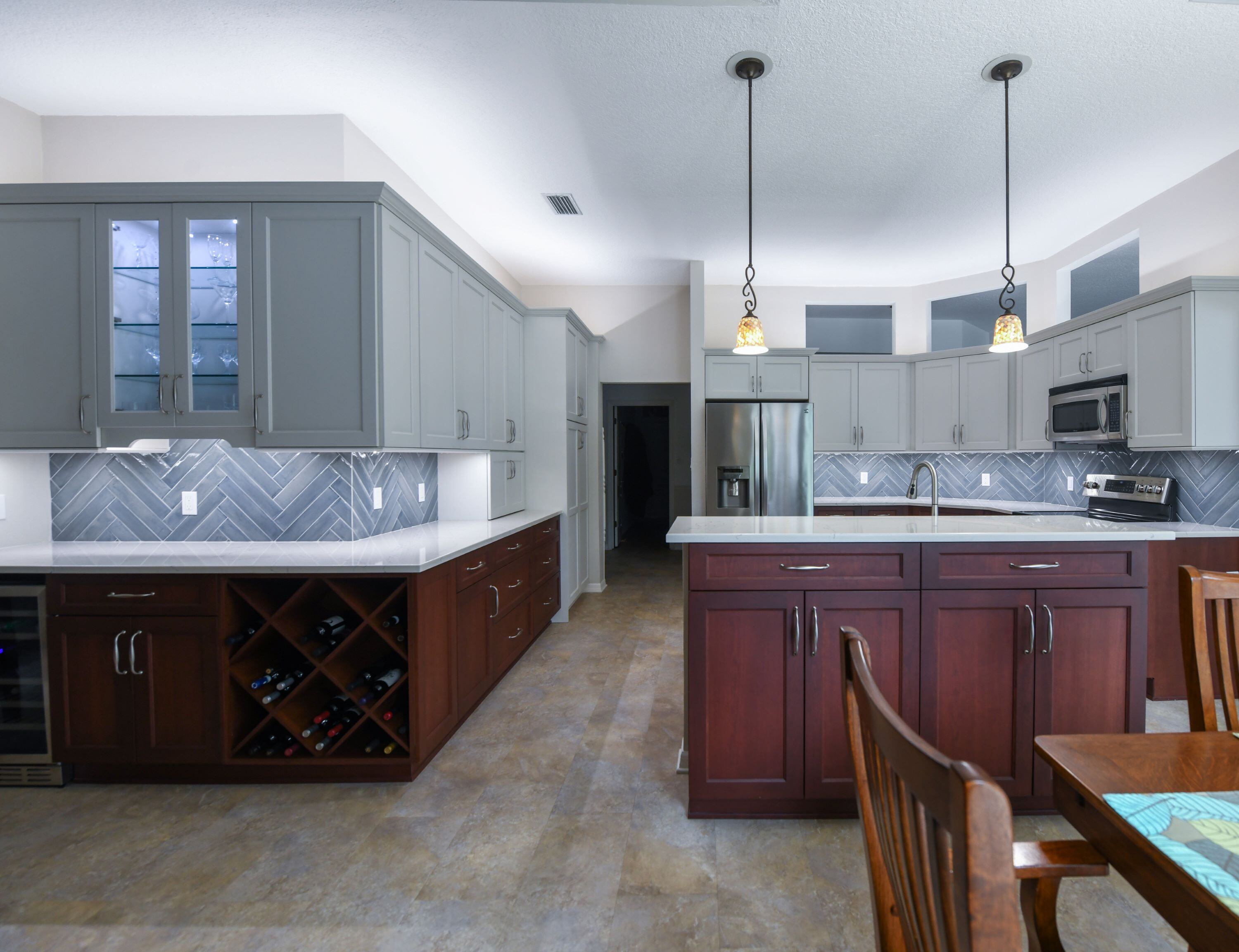 Southern Coastal Kitchen Remodel with Herringbone Backsplash and Blue Cabinets in Sarasota