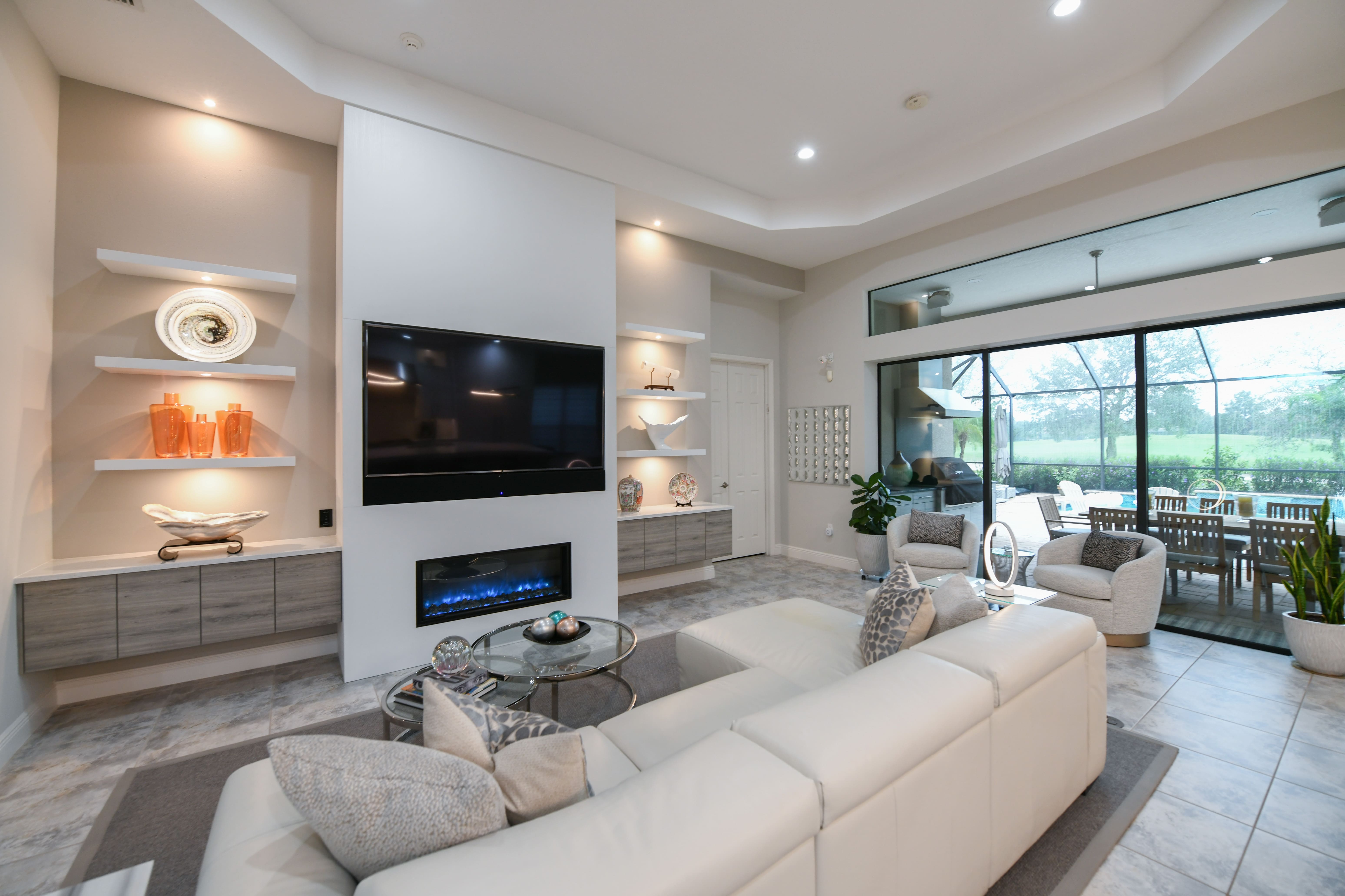 White Sarasota Living Room with Large Windows and Fireplace with Shelving