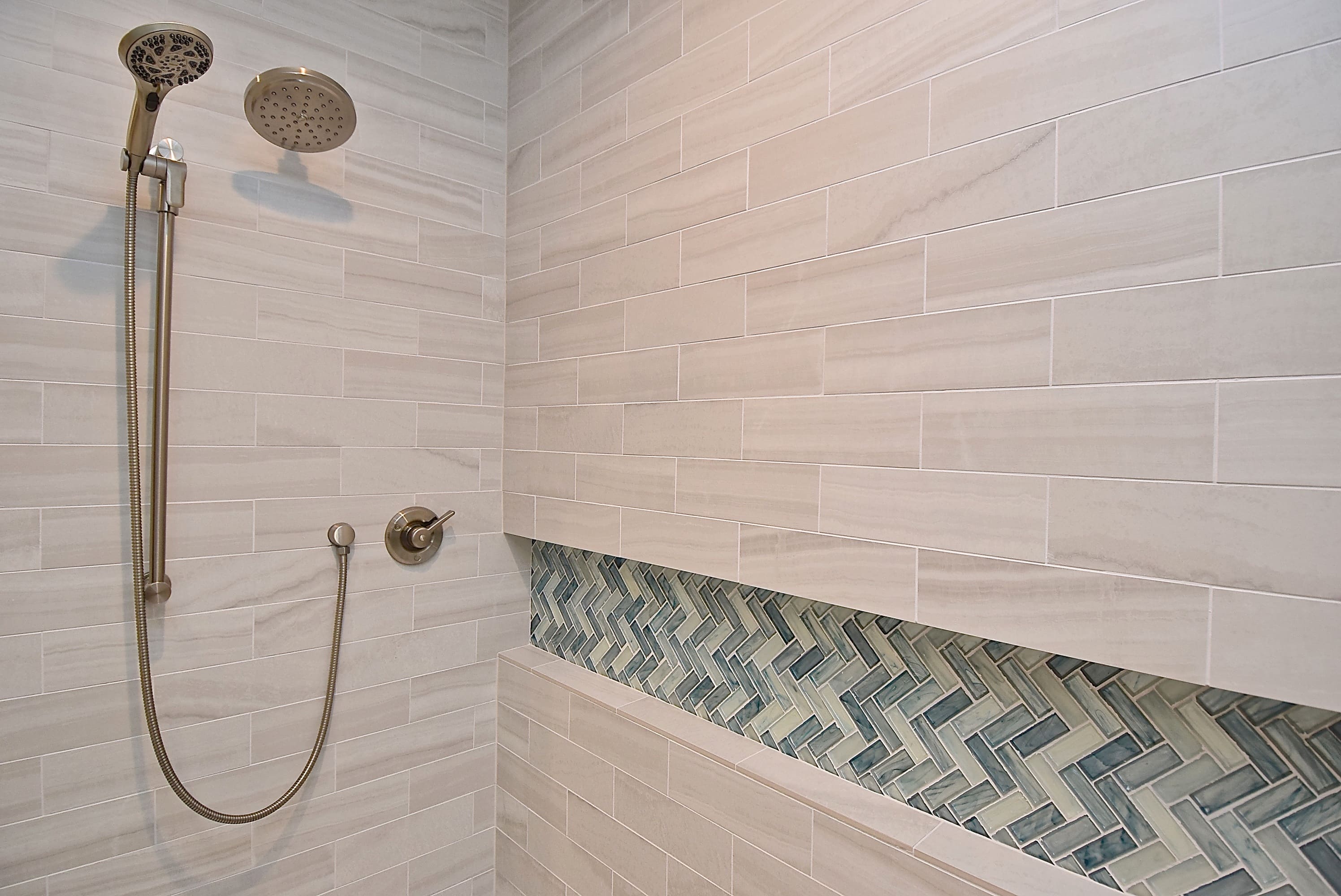 Warm Neutral Shower Tile with Blue Mosaic Glass Tile in Custom Niche for Bradenton Bathroom Remodel 