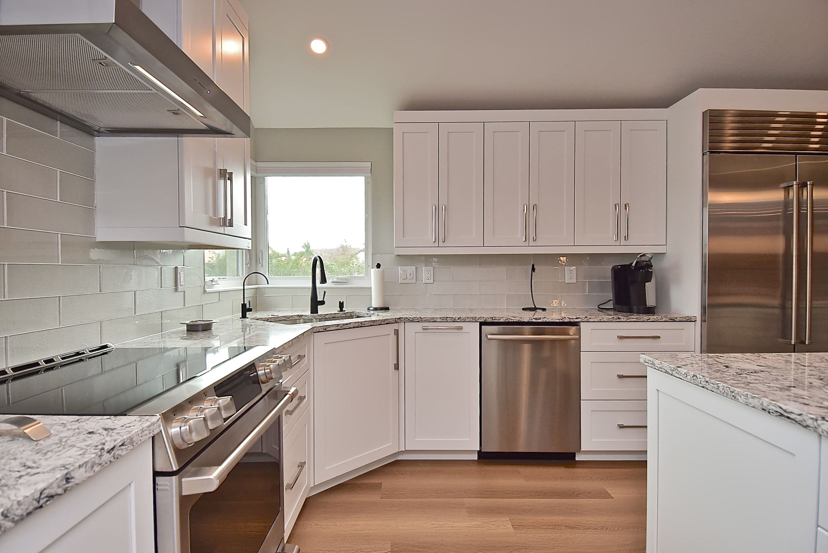 Large Kitchen with Modern White Cabinetry and Stainless Steel Appliances and Island in Bradenton