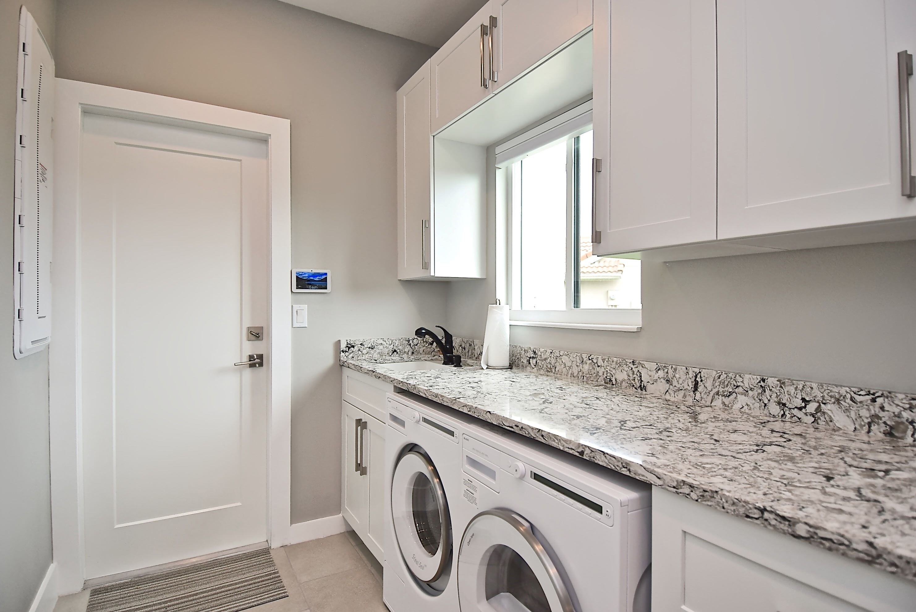 Laundry Room with Cabinets and a Window in Whole Home Remodel